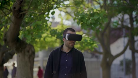 Slow-motion-shot-of-young-man-with-VR-glasses-in-spring-park