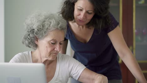 Lächelnde-ältere-Frauen,-Die-Zu-Hause-Mit-Einem-Laptop-Arbeiten.