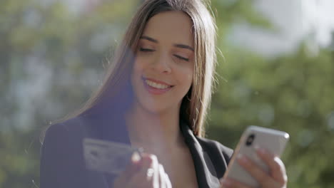 Lächelnde-Junge-Frau-Mit-Smartphone-Und-Kreditkarte