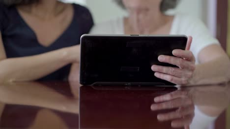 Cropped-shot-of-mature-women-holding-tablet.