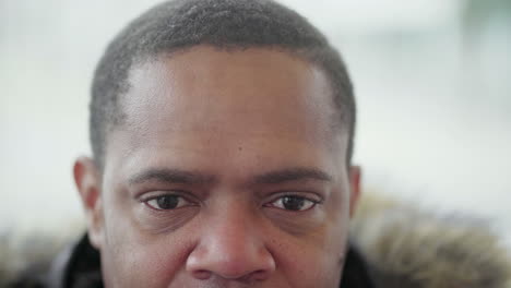 Close-up-shot-of-Afro-American-middle-aged-mans-eyes-looking-at-camera-and-smiling