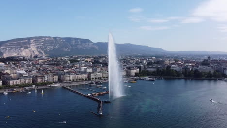 Famous-Water-Fountain-in-Geneva,-Aerial-Reveal-with-Cityscape-and-Lake