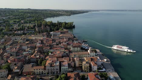 Luftaufnahmen-Der-Fähre,-Die-Vom-Pier-Einer-Bezaubernden-Küstenstadt-In-Italien-Abfährt