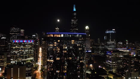 Static-drone-shot-close-to-illuminated-skyscraper-windows-in-moon-lit-Chicago,-USA