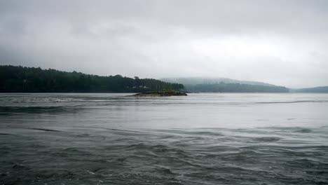Clear-calm-water-enters-reversing-falls-Maine-on-misty-overcast-day