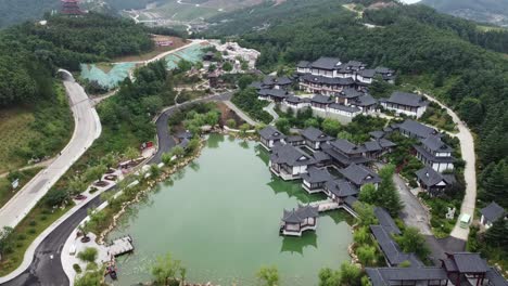 Statische-Drohnenaufnahme-Aus-Der-Luft-Von-Wunderschönen-Traditionellen-Gebäuden-In-Klassischer-Chinesischer-Architektur-Mit-Blick-Auf-Den-See-Und-Eine-Wunderschöne-Chinesische-Landschaft