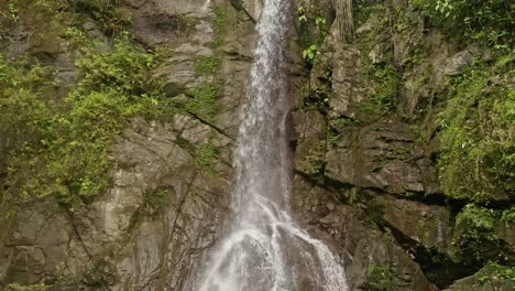 Low-angle-shot-of-remote-Lumondo-waterfall,-deep-in-the-jungle-of-Alegria,-Surigao-Del-Norte,-Philippines-on-a-cloudy-day