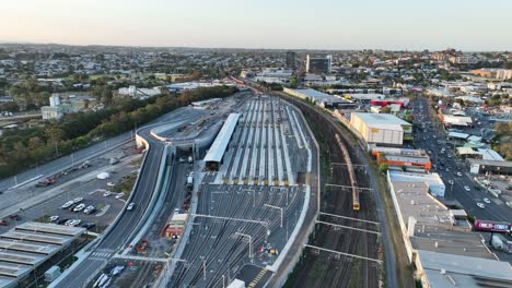 Drohnenschuss-Verfolgt-Den-Zug,-Der-Den-Bahnhof-Brisbane-City,-Mayne,-überquert