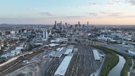 Establishing-shot-of-Brisbane-City,-drone-panning-shot-with-Mayne-Railway-Yard-and-the-ICB-inner-city-bypass
