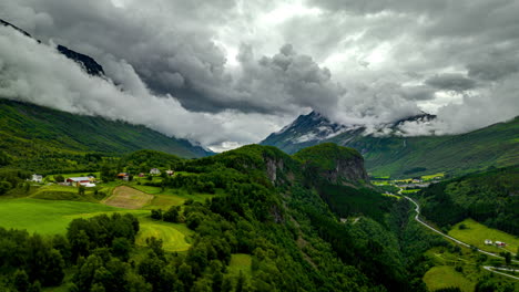 Drohnen-Hyperlapse-Bauschiger-Wolken-Auf-Berggipfeln-Eines-üppigen-Tals,-Aarset,-Norwegen