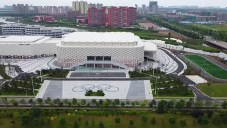Luftschwenk-Einrichtungsaufnahme-Des-Wunderschönen-Weihai-Olympiazentrums-In-Shandong,-China,-Mit-Blick-Auf-Ein-Fußballfeld-Und-Die-Stadt-In-Klassischer-Chinesischer-Architektur-Am-Morgen
