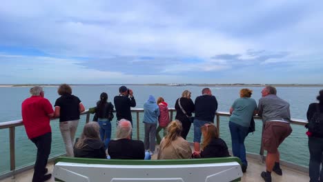 Ferry-passengers-on-boat-at-railing-arriving-at-Texel-Friesland-Island