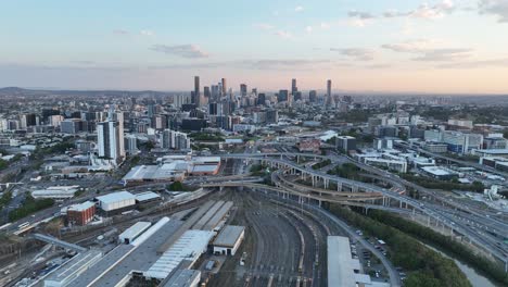 Establishing-pull-away-drone-shot-of-Brisbane-City,-with-Mayne-Railway-Yard-and-the-ICB-inner-city-bypass