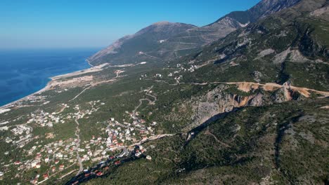Albanian-Ionian-Coastline:-Azure-Seas,-Touristic-Villages,-and-Serpentine-Mountain-Roads-Along-the-Riviera,-Aerial-View