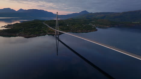 Cinematic-aerial-footage-of-an-impressive-bridge-in-northern-Norway-at-sunset-time,-Drone