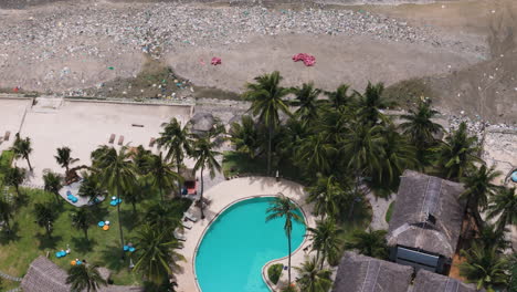 Overhead-view-of-strewn-rubbish-and-plastic-waste-in-front-of-a-beach-resort-near-Ham-Tien,-Phan-Thiet,-Vietnam
