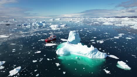 Red-vessel-and-white-ice-in-ocean-near-Greenland,-aerial-view