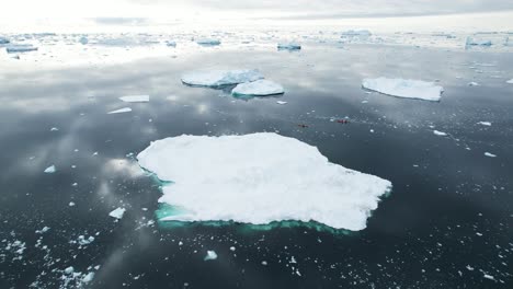 Dos-Kayaks-Y-Un-Enorme-Iceberg-Cerca-De-Groenlandia,-Vista-Aérea
