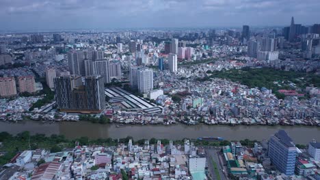 Ho-Chi-Minh-City,-Vietnam-static-aerial-shot-during-day-time-with-boats-on-canal-and-road-traffic-over-bridge-showing-old-and-new-architecture