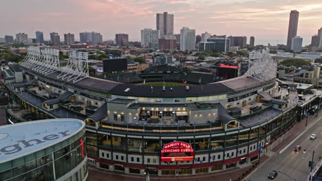 Aerial-view-rising-in-front-of-the-Wrigley-Field-stadium,-sundown-in-Chicago,-USA