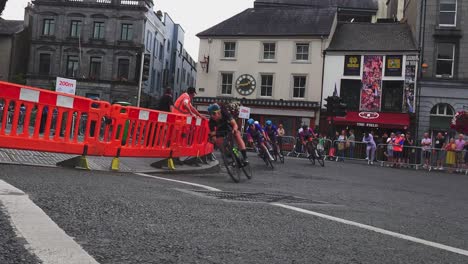 Grupo-De-Carreras-Ciclistas-Femeninas-Corriendo-A-Través-De-Una-Curva-A-Gran-Velocidad-En-La-Ciudad-De-Kilkenny,-Irlanda,-En-Una-Cálida-Tarde-De-Otoño