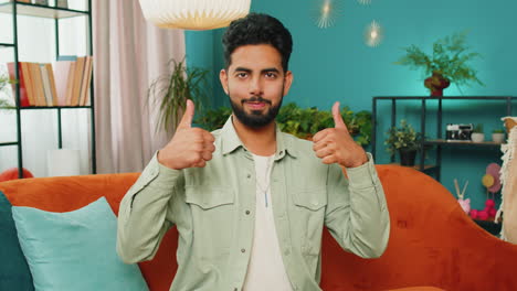 Happy-Indian-young-man-looking-approvingly-at-camera-show-thumbs-up-like-positive-sign-good-news