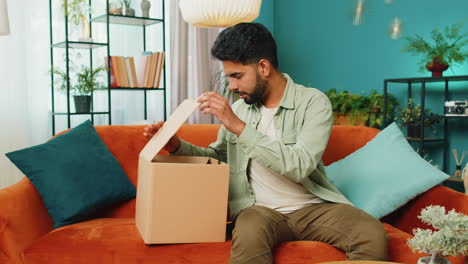 Angry-dissatisfied-shopper-Indian-man-unpacking-parcel-feeling-upset,-confused,-wrong-delivery