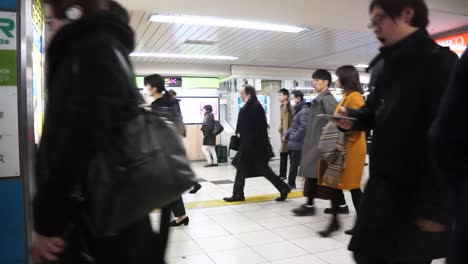 Toma-En-Cámara-Lenta-De-Pasajeros-Caminando-En-La-Estación-De-Metro-En-Tokio,-Japón