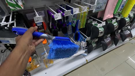POV-shot,-a-customer-is-buying-toilet-brushes-in-a-supermarket
