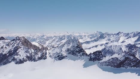 Wunderschöne-Filmische-Luftaufnahmen-Von-Schneebedeckten-Alpinen-Gletschergipfeln