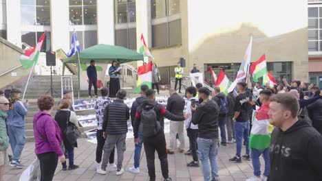 Female-speaker-leads-a-demonstration-of-young-people-holding-Kurdistan-flags