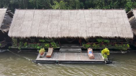 Panoramic-drone-view-of-tourists-enjoying-the-day-along-the-River-Kwai-at-their-floating-hotels-in-Kanchanaburi,-Thailand