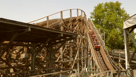 Gente-Viajando-En-La-Montaña-Rusa-De-Madera-Tomahawk-En-El-Parque-De-Atracciones-Portaventura-En-Salou,-España