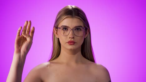 Medium-shot-of-a-young-beautiful-woman-with-a-glasses-while-she-makes-a-hand-signal-with-her-hand-for-a-call-for-help-because-she-needs-help-and-is-in-danger