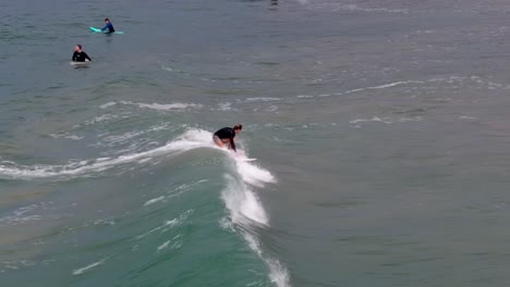 Aerial-slow-motion-view-of-single-surfer-riding-out-wave-in-Malibu-beach