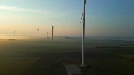 Eine-Reihe-Von-Windkraftanlagen,-Die-Im-Morgennebel-Strom-Erzeugen