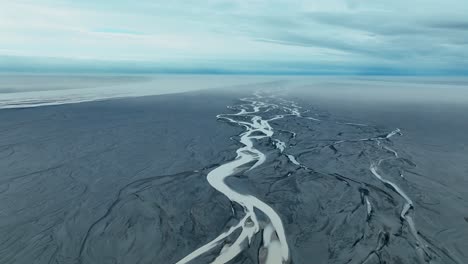 Aerial-View-Over-Rivers-On-Black-Sand-Beach-In-Iceland---drone-shot