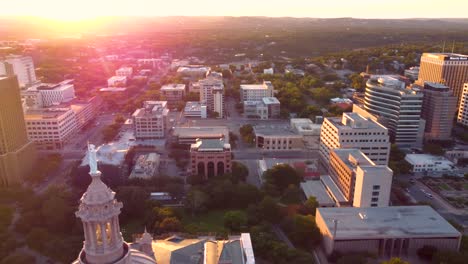 Edificio-De-La-Capital-Del-Estado-De-Austin,-Texas,-Disparo-Aéreo-De-Un-Dron-Rodeando-La-Estatua-De-La-Diosa-De-La-Libertad-En-La-Parte-Superior-Con-Vistas-De-La-Universidad-De-Texas-En-Austin-Y-El-Horizonte-De-Los-Edificios-Del-Centro-De-La-Ciudad-Al-Atardecer-En-4k