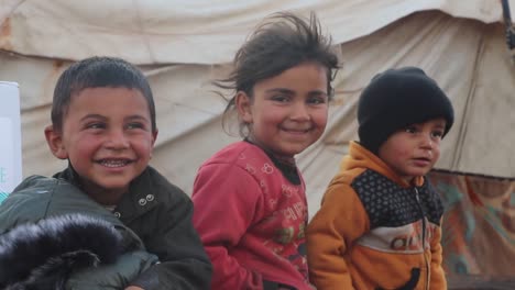 poor-refugee-children-outside-shelter-with-innocent-smiles-on-faces