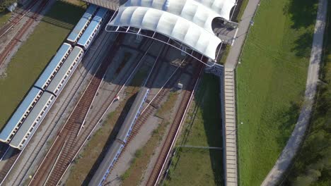 Majestic-aerial-top-view-flight-train-arrives-Trainstation-city-town-Munich-Germany-Bavarian-Subway,-summer-sunny-blue-sky-day-23