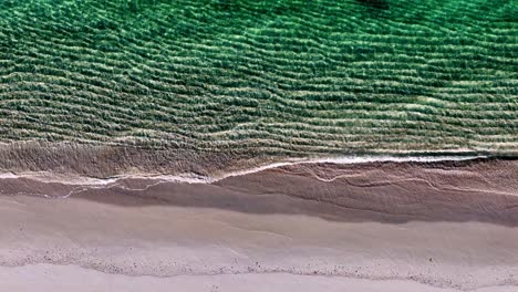 Ein-Friedlicher-Strand-Mit-Wellen,-Die-Auf-Den-Sand-Krachen,-Und-Einer-Grünen-Meereswelle,-Die-Vom-Ufer-Hereinkommt,-Und-Einer-Grünen-Meereswelle,-Die-Von-Oben-Hereinkommt