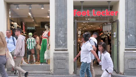 Se-Ven-Peatones-Y-Compradores-En-La-Multinacional-Estadounidense-Minorista-De-Ropa-Y-Calzado-Deportivo,-Foot-Locker,-Tienda