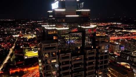 Dron-Cinematográfico-Filmado-Alrededor-De-Una-Plaza-Truista-Reflejada-E-Iluminando-El-Paisaje-Urbano-De-La-Ciudad-De-Atlanta-A-Medianoche