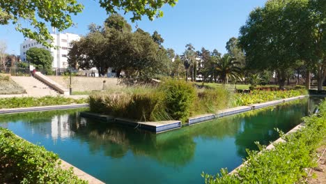 Serene-Rabat-Botanical-Garden-with-pond,-lush-greenery,-and-architectural-detail