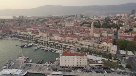 Aerial:-Croatia-Split's-harbor-with-docked-boats-and-mountainous-backdrop