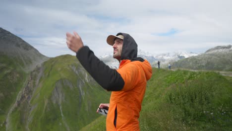 Medium-close-up-of-man-wearing-orange-jacket-take-off-drone-with-hands,-static