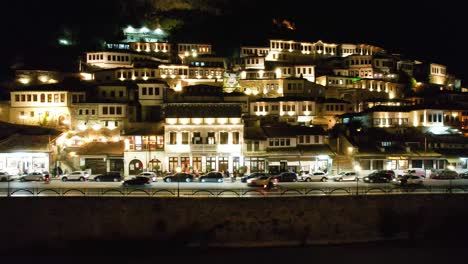 Noche-De-Berat:-Deleite-Turístico-Mientras-Las-Casas-Mangalem-Se-Iluminan-Con-Ventanas-Y-Luces-Brillantes-En-El-Paseo-Sobre-El-Río-Osum