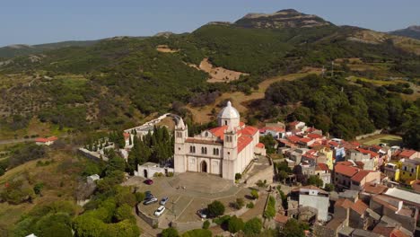 Scenic-aerial-shot-of-Santa-Maria-della-Neve-church-on-top-of-hill-in-Cuglieri