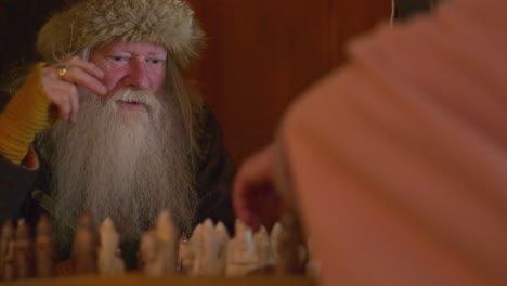 Cinematic-slow-motion-shot-of-a-Viking-playing-chess-in-the-Viking-Valley-of-Norway,-Europe