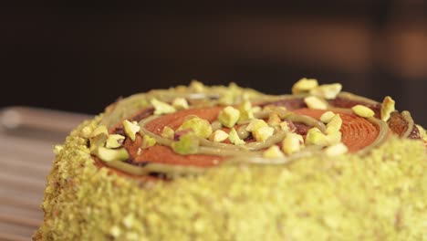 Pistachio-donut-being-decorated-dried-raspberry-side-view